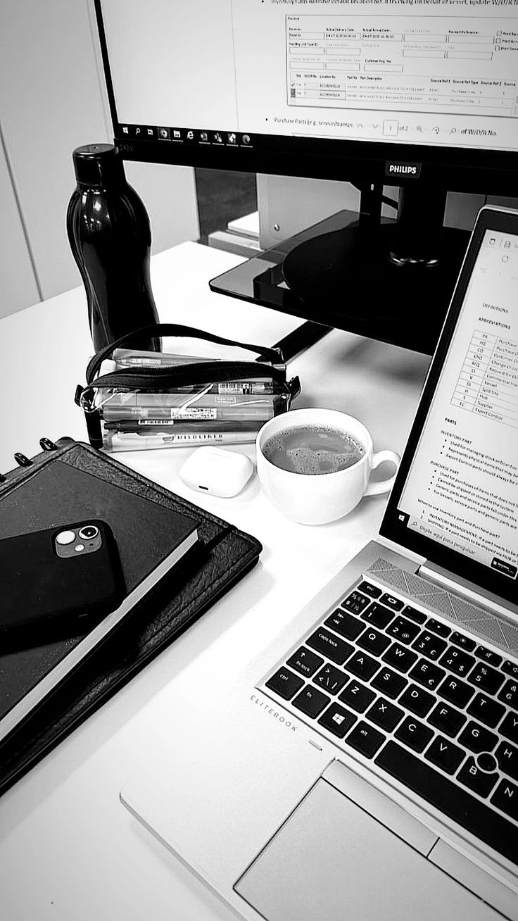 This may contain: an open laptop computer sitting on top of a desk next to a cup of coffee