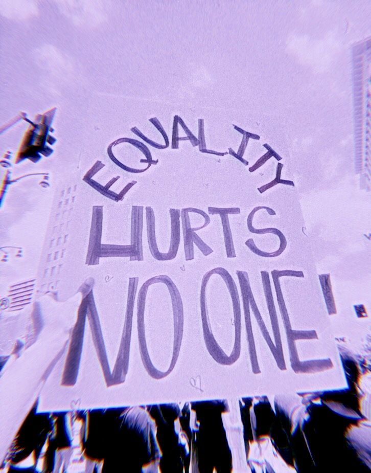 This may contain: there is a sign that says equality hurts no one in front of some people walking down the street