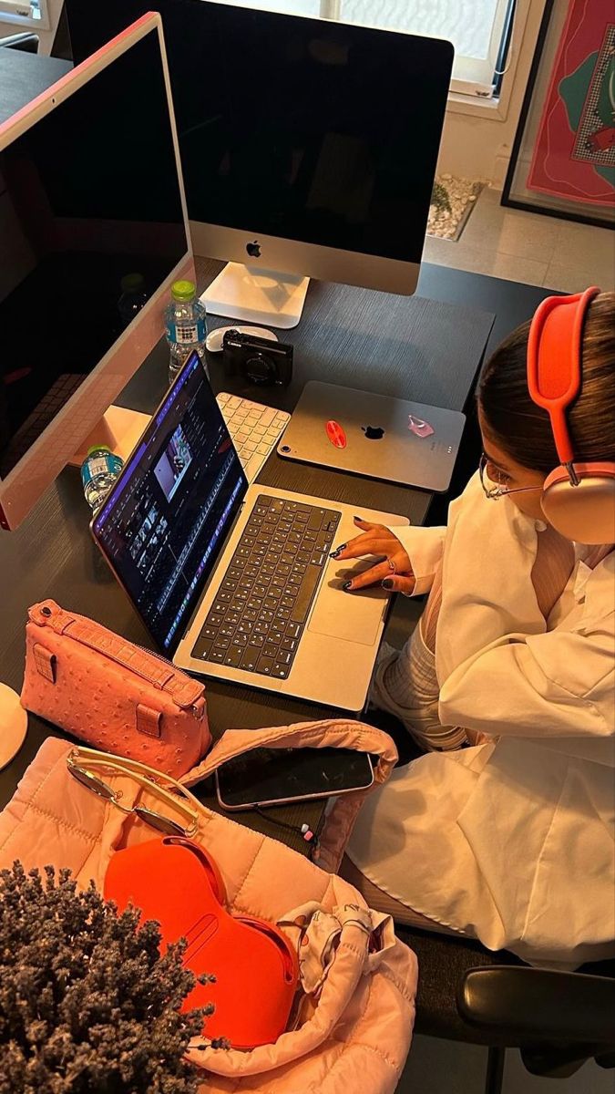 This may contain: a person sitting at a desk with a laptop and headphones