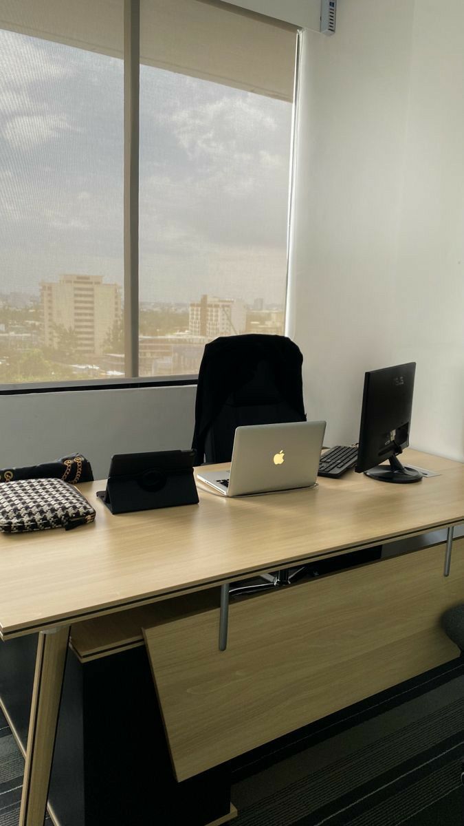 This may contain: an office desk with a laptop, keyboard and mouse on it in front of a window