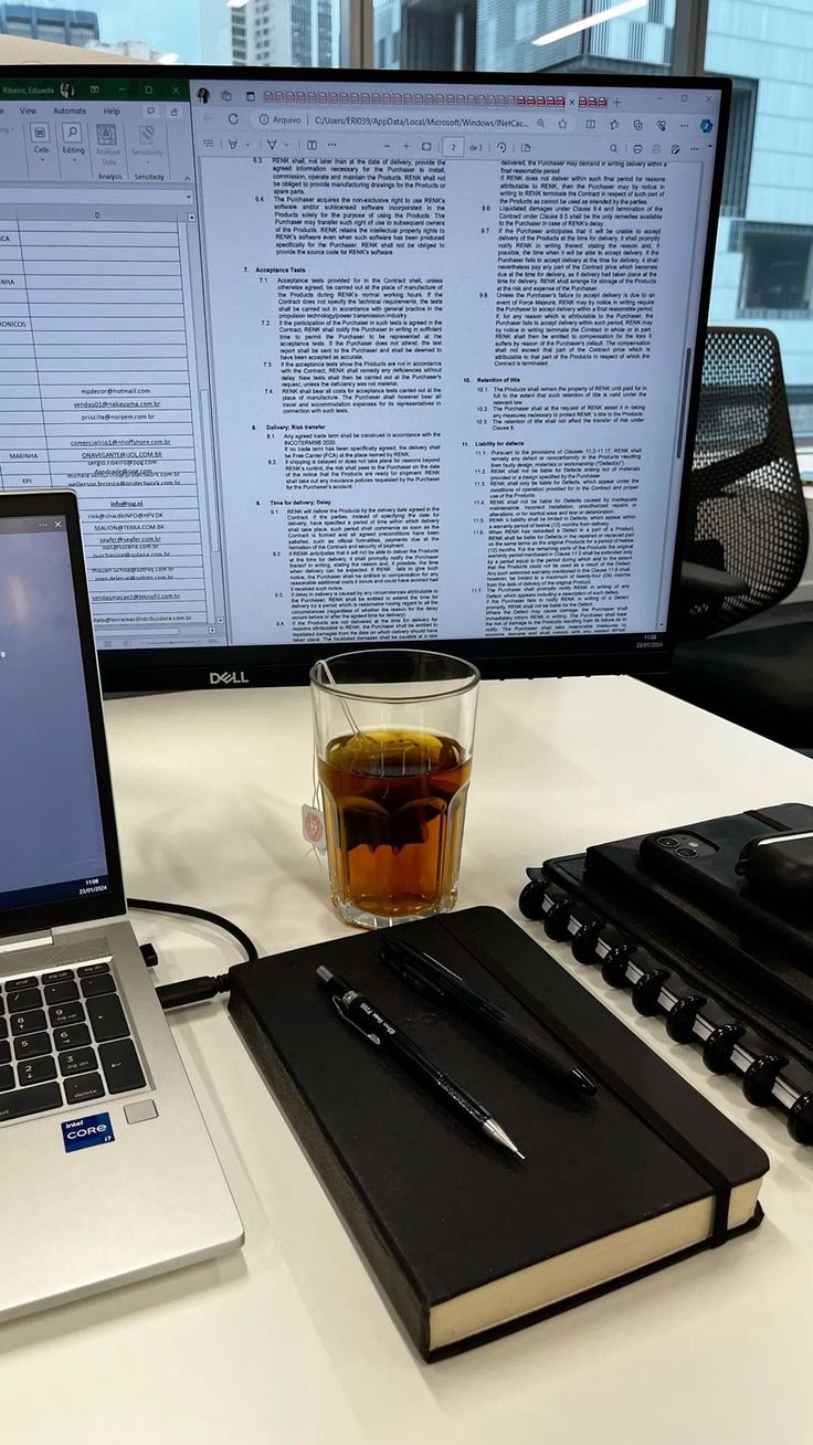 This may contain: an open laptop computer sitting on top of a desk next to a cup of tea