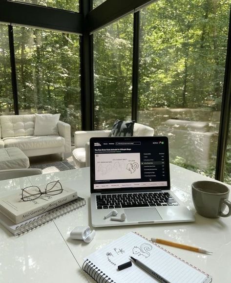 This may contain: an open laptop computer sitting on top of a white table next to a cup of coffee