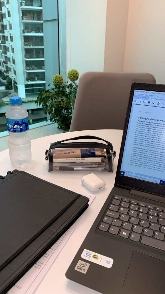 This may contain: an open laptop computer sitting on top of a white table next to a water bottle