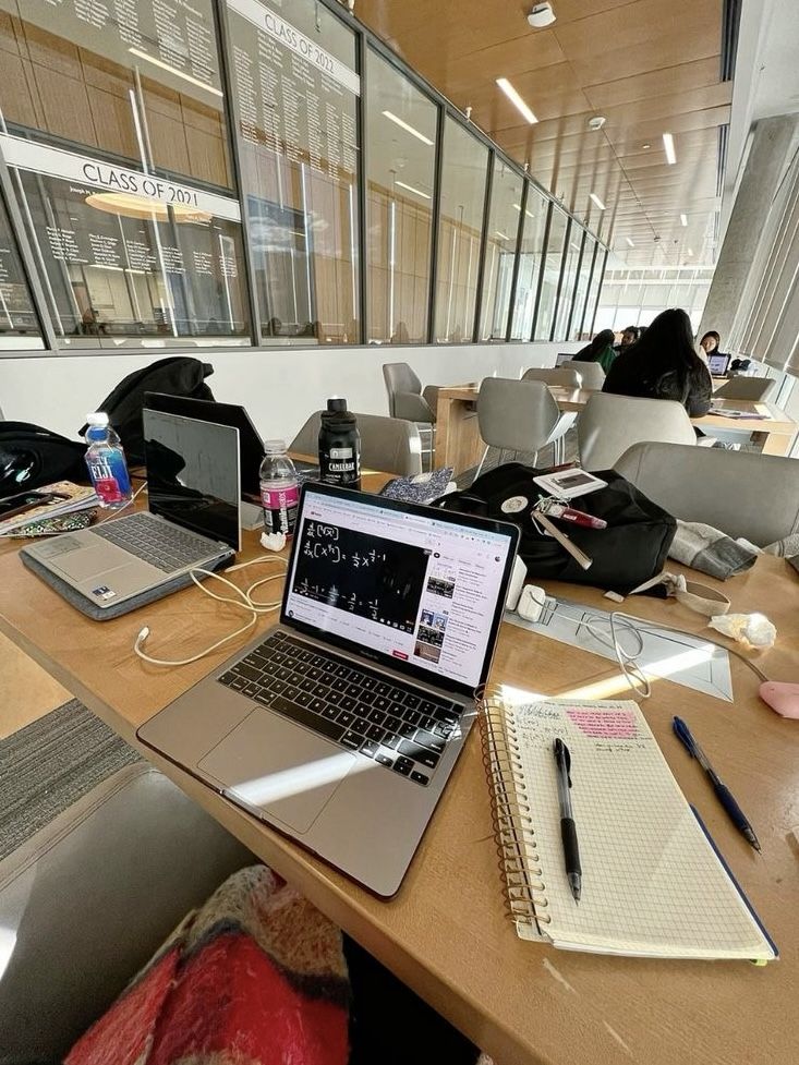 This may contain: an open laptop computer sitting on top of a wooden desk