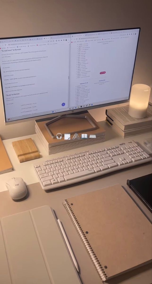 This may contain: a computer monitor sitting on top of a desk next to a keyboard and notebooks