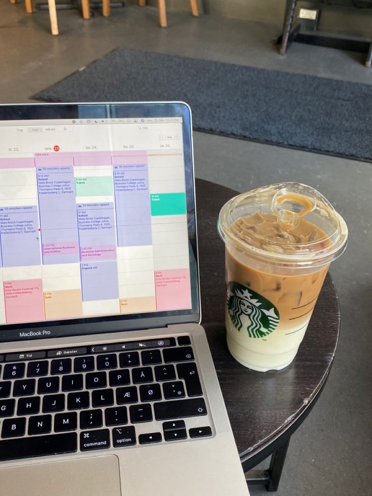 This may contain: a laptop computer sitting on top of a table next to a cup of coffee