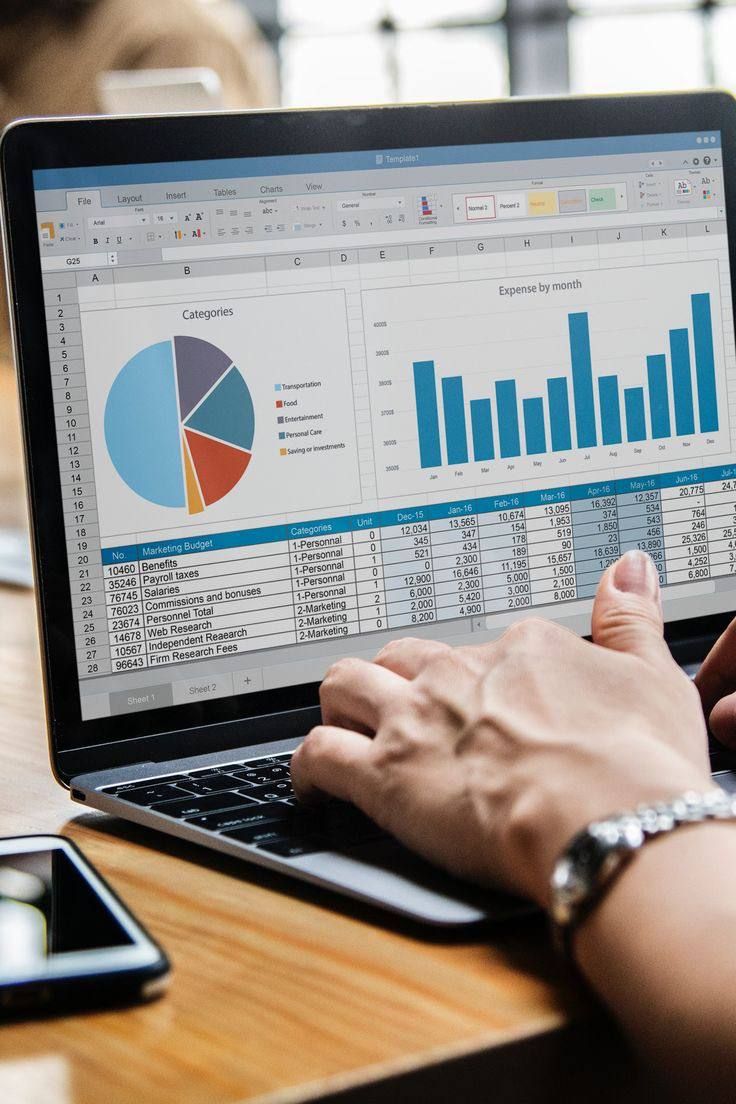 This may contain: a person using a laptop computer on top of a desk with graphs and calculator