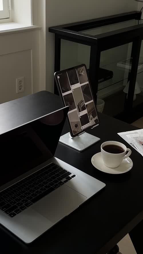This may contain: an open laptop computer sitting on top of a desk next to a cup of coffee