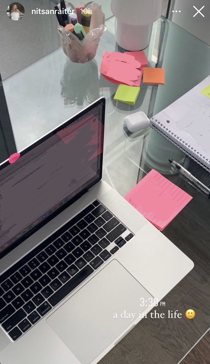 This may contain: an open laptop computer sitting on top of a desk next to sticky notes and pens