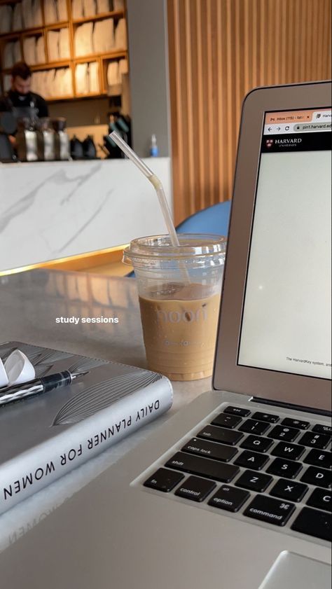 This may contain: an open laptop computer sitting on top of a white desk next to a cup of coffee