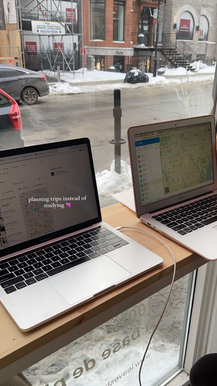 This may contain: two laptops are sitting on a window sill in front of a snowy street